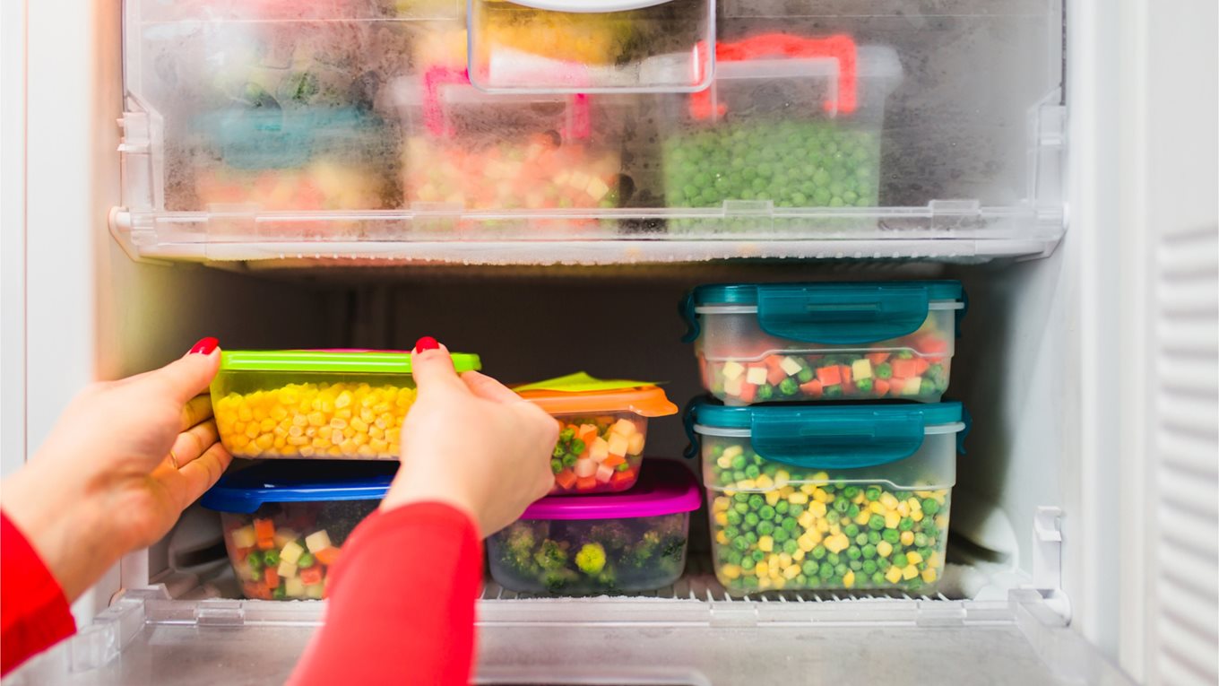 Containers of vegetables in a freezer