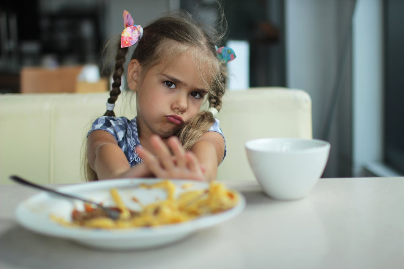 Unhappy child pushing away a plate