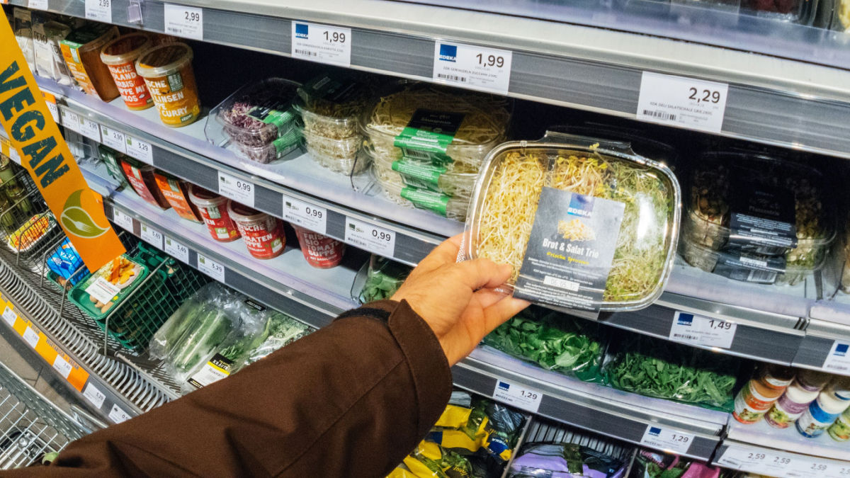 Man's hand choosing a pre-packed vegan salad in the supermarket