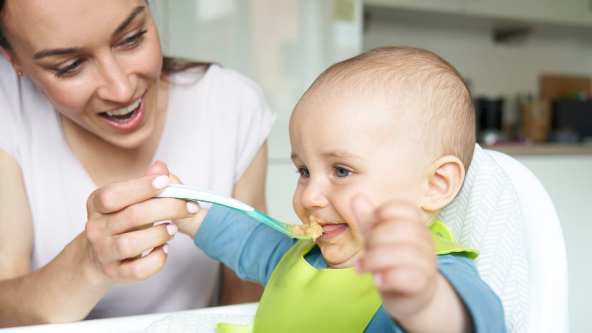 Mother feeding baby with weaning food