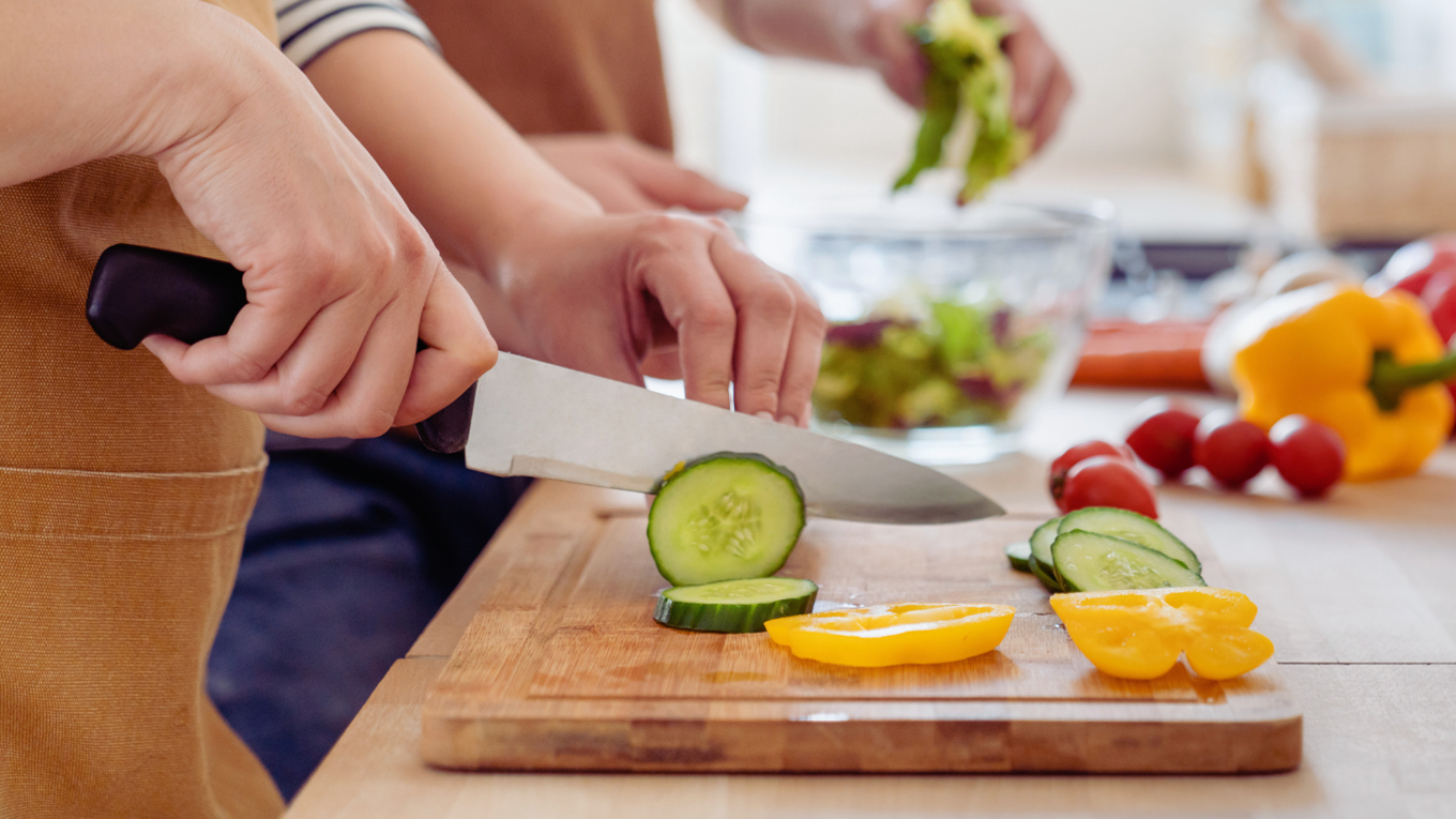 Man and women cutting vegetables